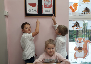 dzieci pokazują symbole narodowe na tablicy